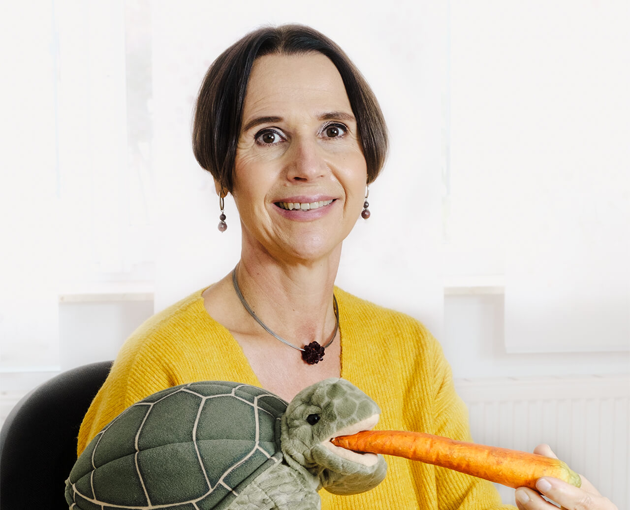 Bettina Hunsdorfer zeigt Kinder anhand einer Schildkröten-Puppe, wie das Schlucken funktioniert